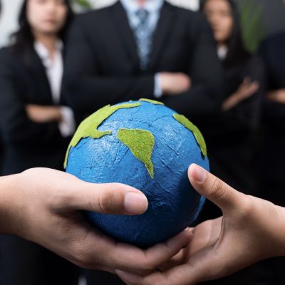 Business people holding Earth together in synergy, Quaint Top view business people holding Earth together in synergy as team building to utilize eco regulation for environmental protection by reducing CO2 emission to save Earth. Quaint